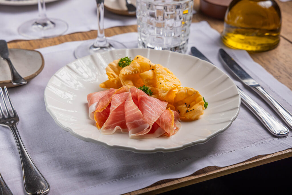 
Ristorantino-Prosciutto-di-Parma-con-torta-fritta-e-burro-aromatizzato-alle-erbe-5-Mario-Rodrigues-scaled.