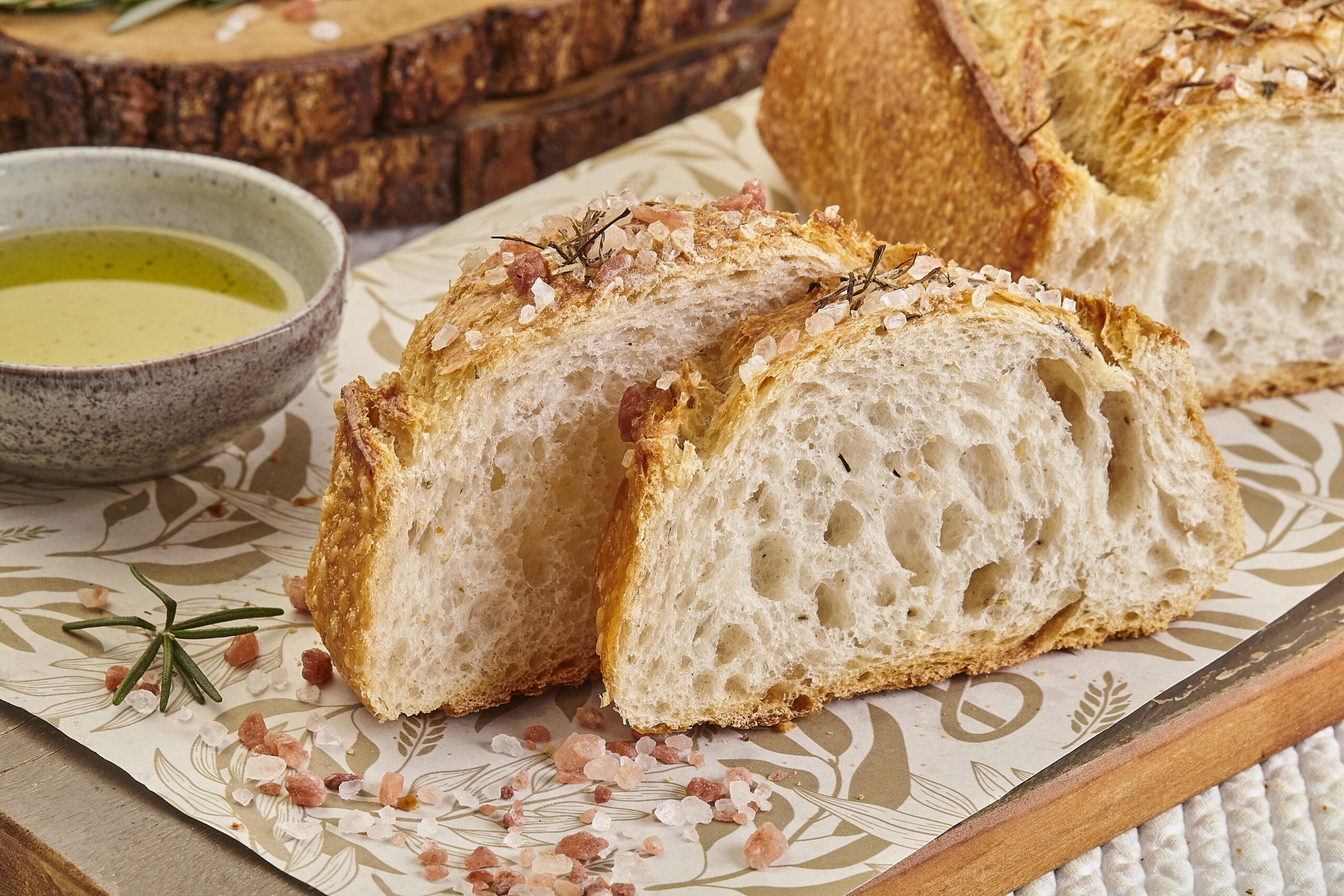 Pão de fermentação natural fatiado ao lado de azeite